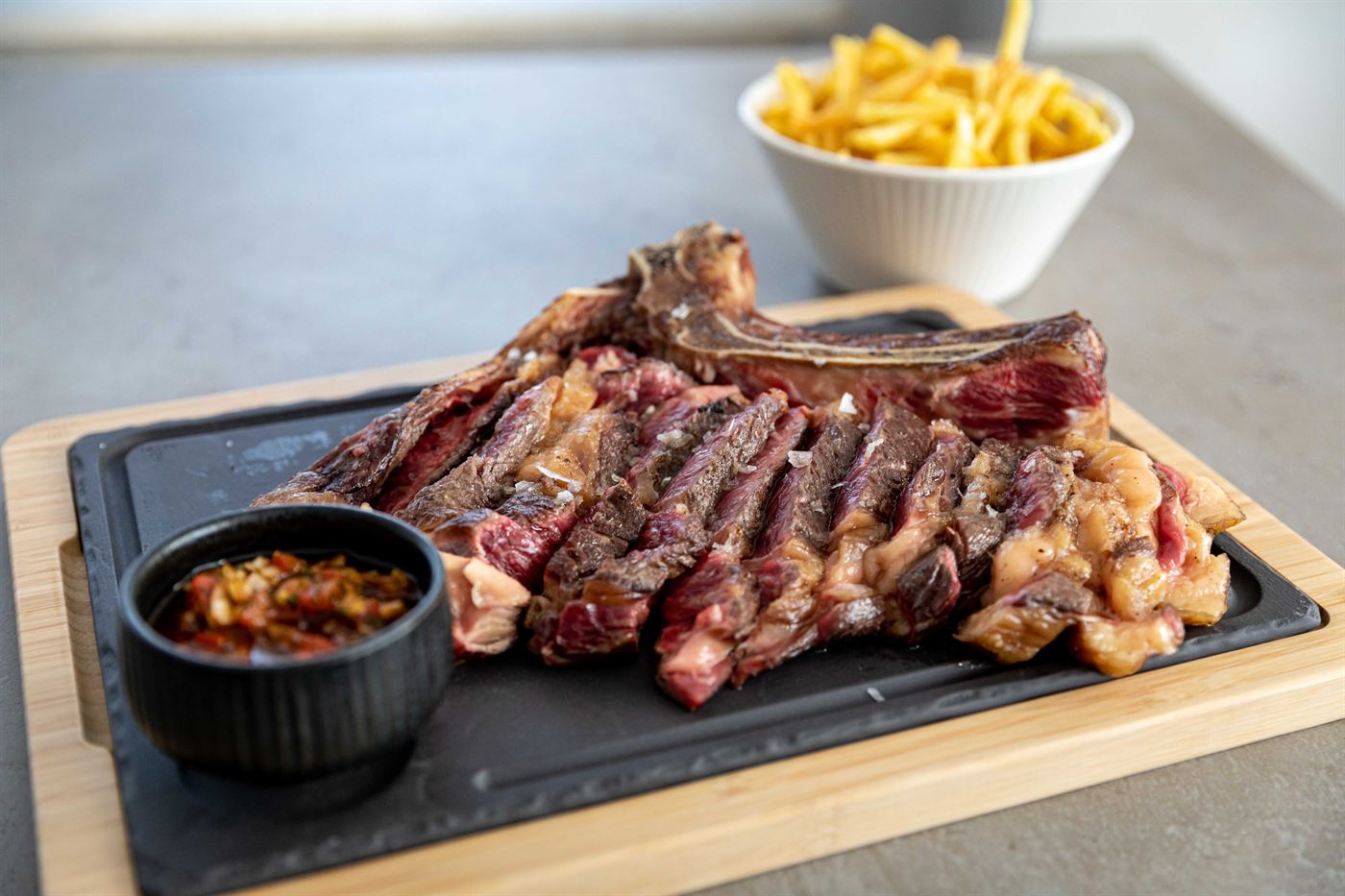 Grilled beef chop, sliced, with fried potatoes