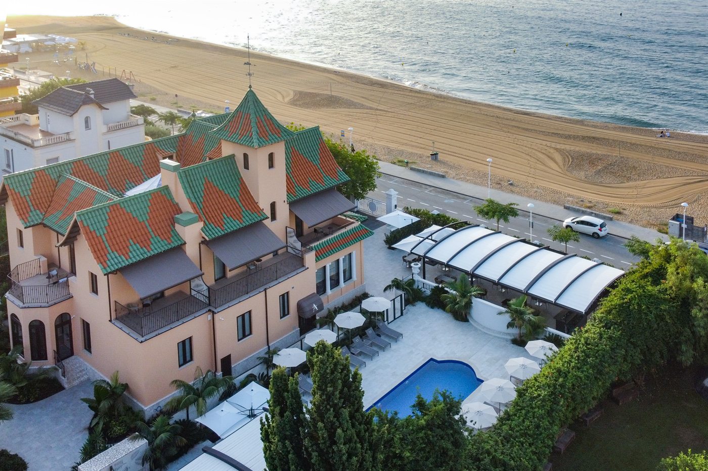 The villa, its pool and the beach behind it, seen from the air