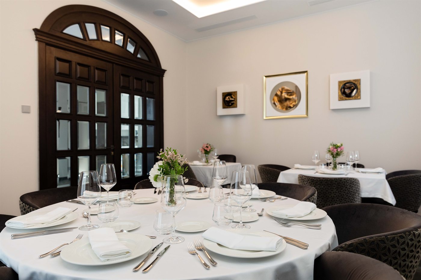 A round table laid for dinner in the indoor dining room