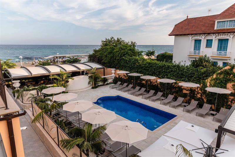 The swimming pool and loungers overlooking the sea