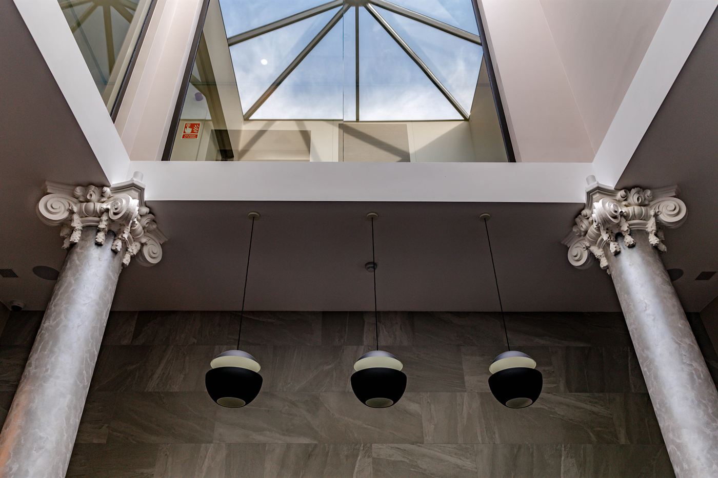 The hotel atrium, white columns rising to a skylight